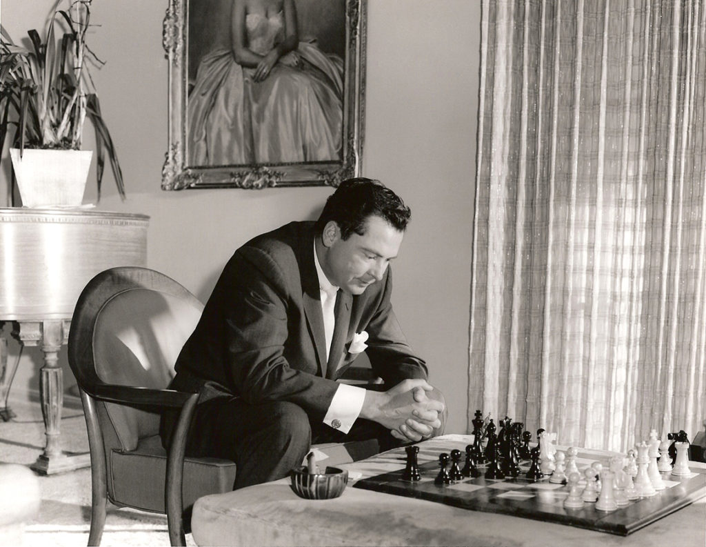 Barron Hilton contemplates his next move while playing chess